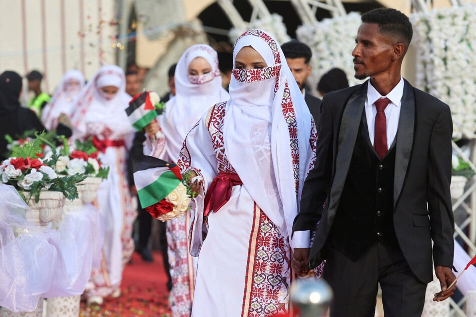 Palestinian couples attend a mass wedding in Khan Younis, in the southern Gaza Strip, on December 2, 2025.
