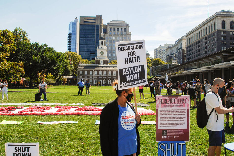 Immigrants' rights activists rally in front of independence Hall in Philadelphia, Pennsylvania, demanding reparations and asylum for Haitian refugees.
