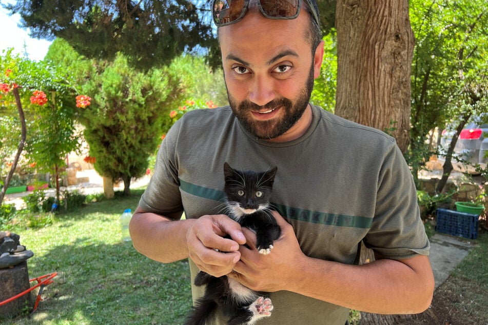 Reuters journalist Issam Abdallah holding a kitten while posing for a picture in Saaideh, Lebanon, on July 4, 2023. He was killed in an Israeli strike on seven journalists.