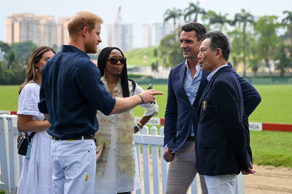 Britain's Prince Harry (2nd L) speaks with Sophie Chandauka (C), chair of the Sentebale board, and Dan Carter (2nd R), former All Blacks rugby player and current ISPS Handa ambassador, at the Sentebale ISPS Handa Polo Cup in Singapore on August 12, 2023.