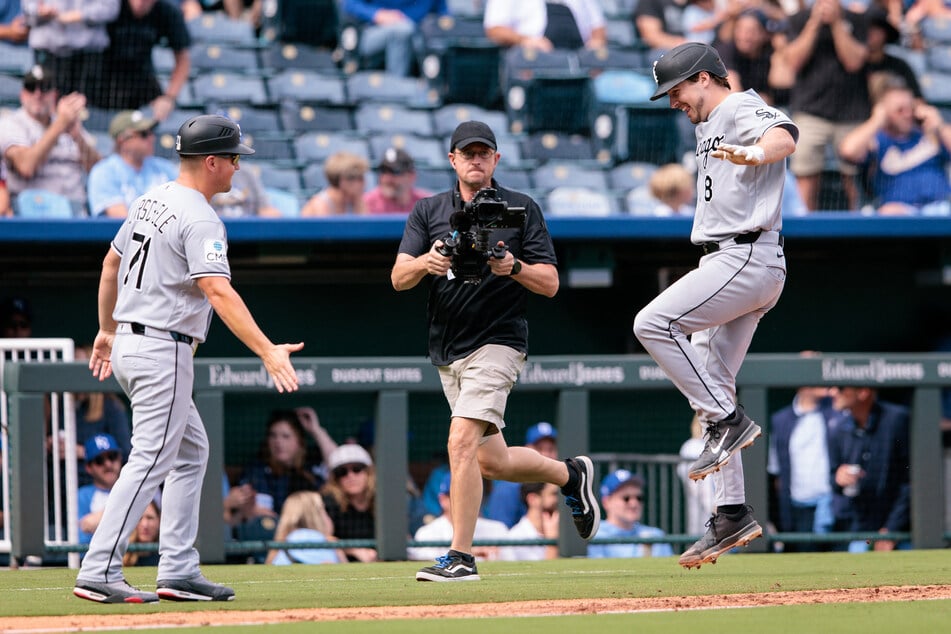 Chicago White Sox catcher Kyle Teel (r.) reacts before slapping hands with third base/infield coach Justin Jirschele (l.) after hitting a home run on September 24, 2026. The team secured their MLB postseason berth after defeating the Kansas City Royals.