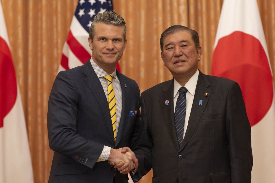 US Secretary of Defense Pete Hegseth (l.) shakes hands with Japan's Prime Minister Shigeru Ishiba (r.) during their meeting at the Prime Minister's office in Tokyo on Sunday.