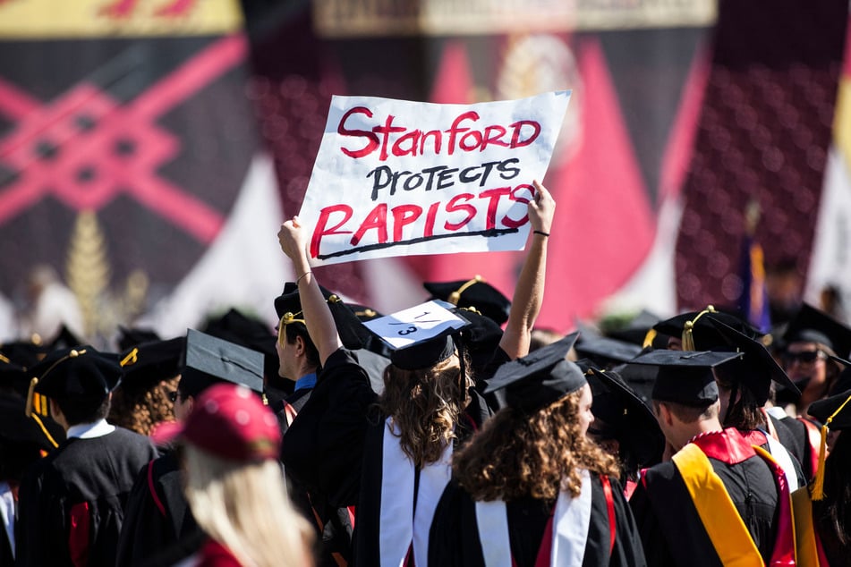 Graduating student Andrea Lorei holds a sign in protest before Stanford University's commencement ceremony on June 12, 2016. Experts say Cornell's response to the alleged gang rape is "typical of other universities."