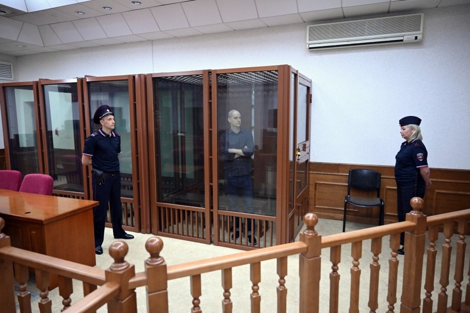 Evan Gershkovich looks out from inside a glass defendants' cage prior to a hearing in Yekaterinburg's Sverdlovsk Regional Court on June 26, 2024.