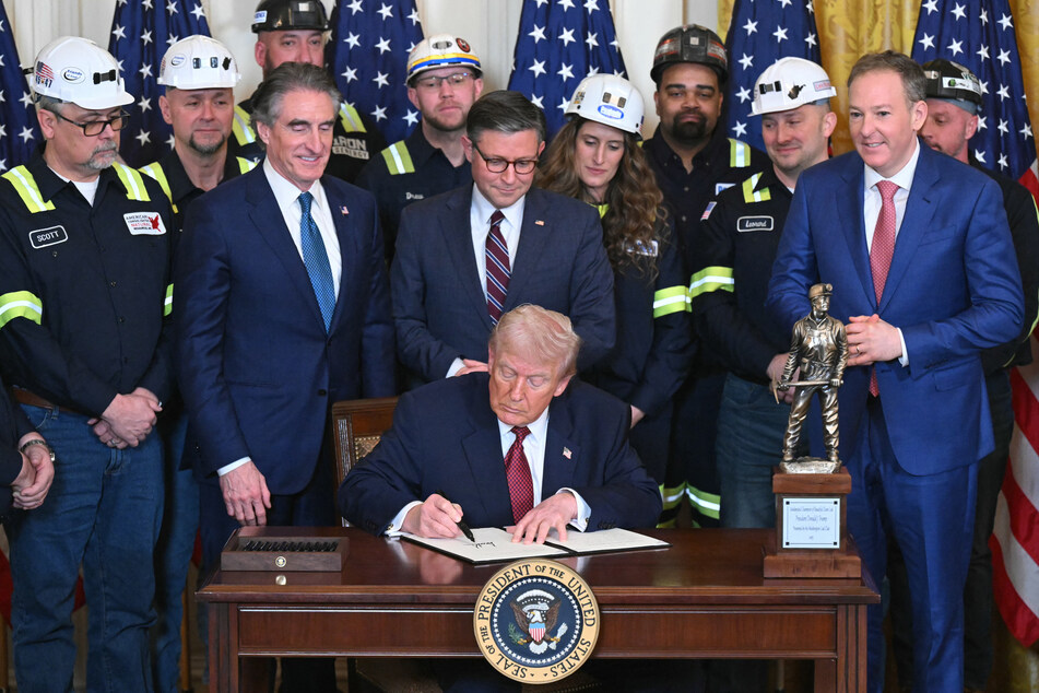 Secretary of the Interior Doug Burgum, House Speaker Mike Johnson, and EPA Administrator Lee Zeldin watch as President Donald Trump signs an executive order directing the military to purchase electricity from coal-fired power plants on February 11, 2026.