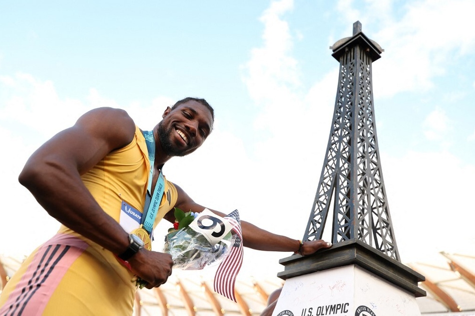 Noah Lyles poses with a miniature Eiffel Tower after winning the men's 200m final at the 2024 US Olympic Team Track & Field Trials.