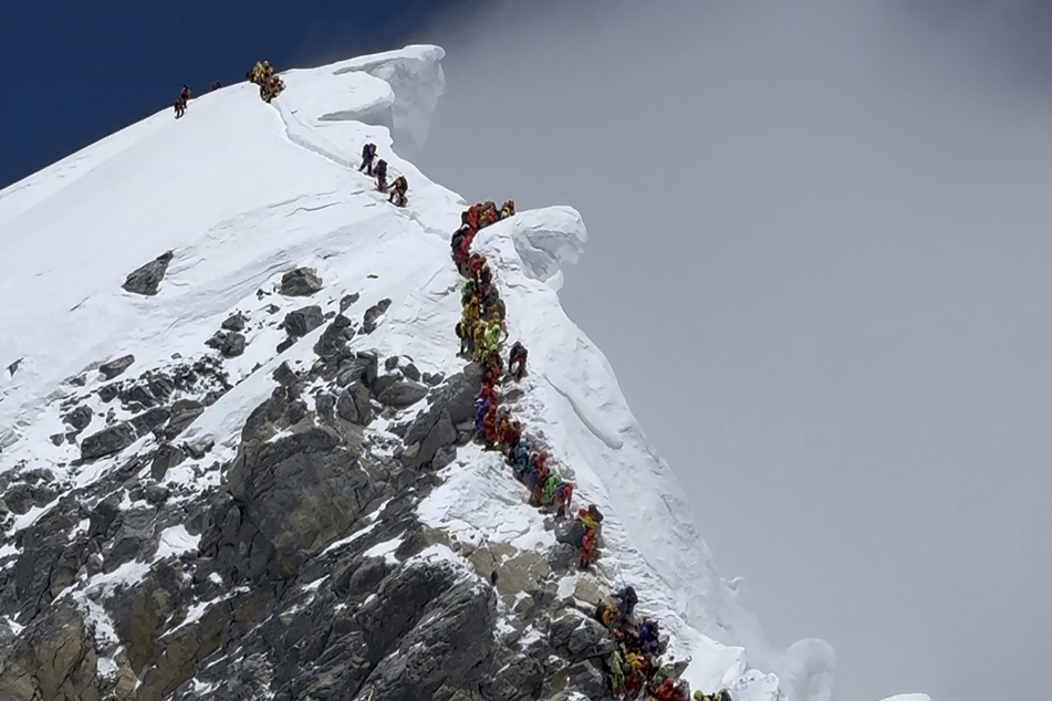 This photograph, taken on May 20, 2026, shows mountaineers climbing a slope lined up during their ascent from the Hillary Step to summit Mount Everest in Nepal.