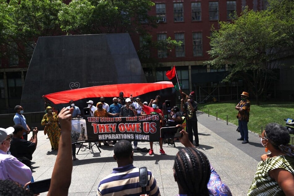 People listen to speakers during a July 2021 rally for reparations at the African Burial Ground National Monument in New York City.