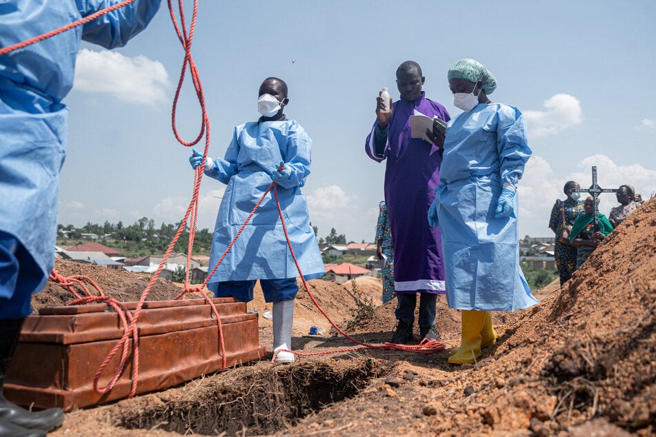 Teams from the International Federation of the Red Cross and Red Crescent Societies prepare for burial at Mbiyo cemetery the body of a fourth orphan who died from Ebola virus disease at an orphanage in Bunia, Ituri Province.