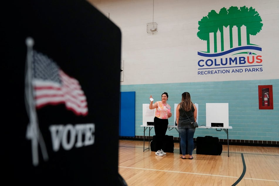 Volunteers help voters cast their ballots during a special election for Issue 1 at the Schiller Recreation Center in Columbus, Ohio.