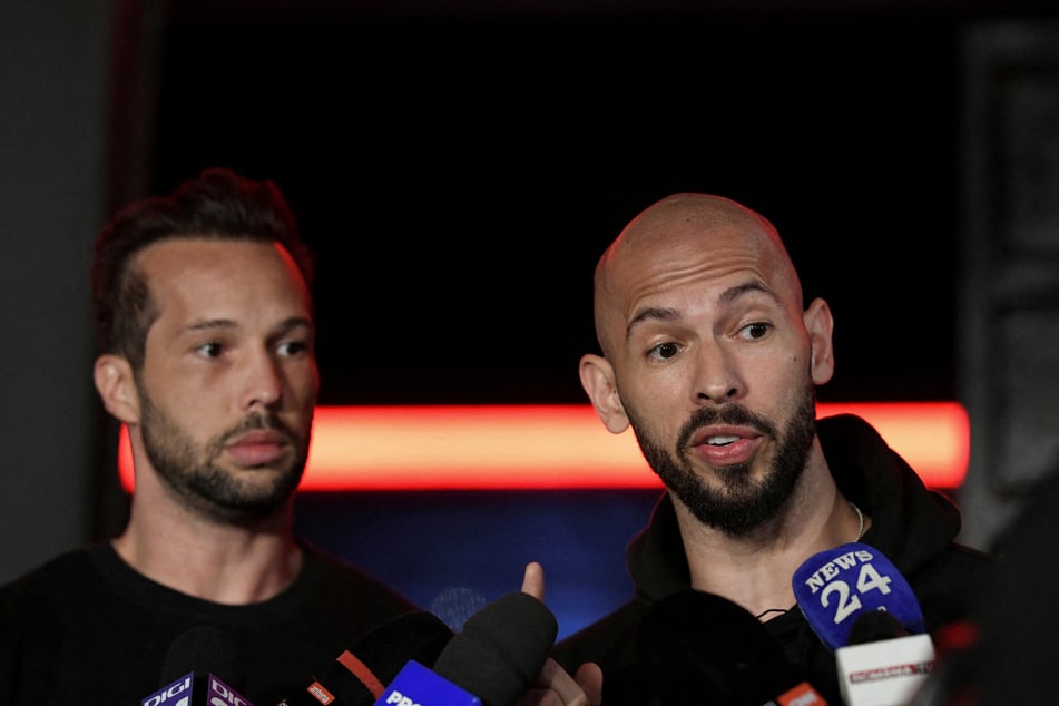 Tristan (l.) and Andrew Tate (r.) deliver a press statement in front of their house after landing back in Romania on March 22, 2025. The brothers are accused of trafficking and sex crime offenses.