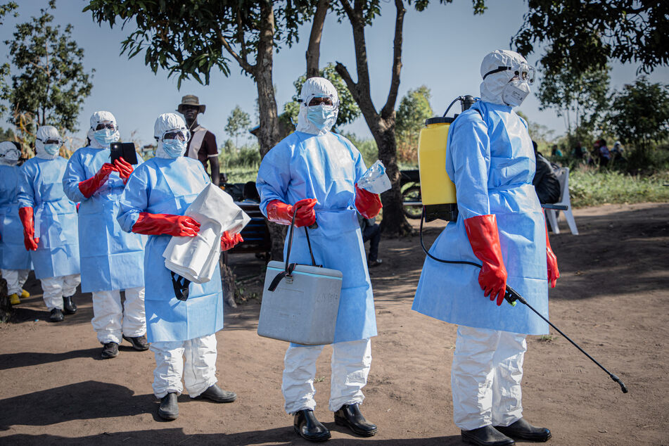 Volunteers wearing personal protective equipment prepare to leave to recover the body of a three-year-old child presumed dead from Ebola in Bunia on June 11, 2026.
