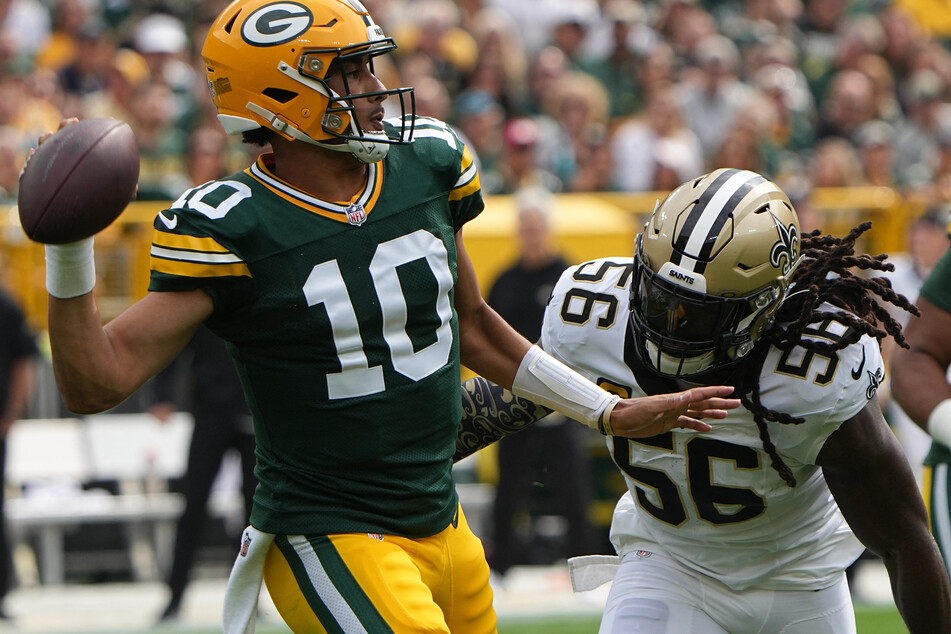 Green Bay Packers quarterback Jordan Love is pressured by New Orleans Saints linebacker Demario Davis during the first quarter at Lambeau Field.