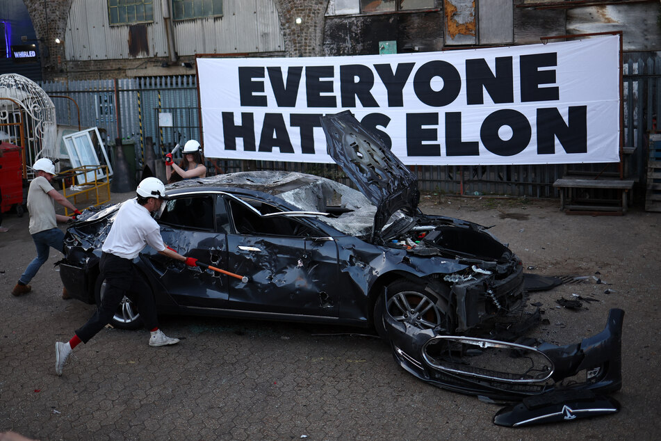 People smash a Tesla car during anti Elon Musk protest at Hardess Studios in south London on April 10, 2025.