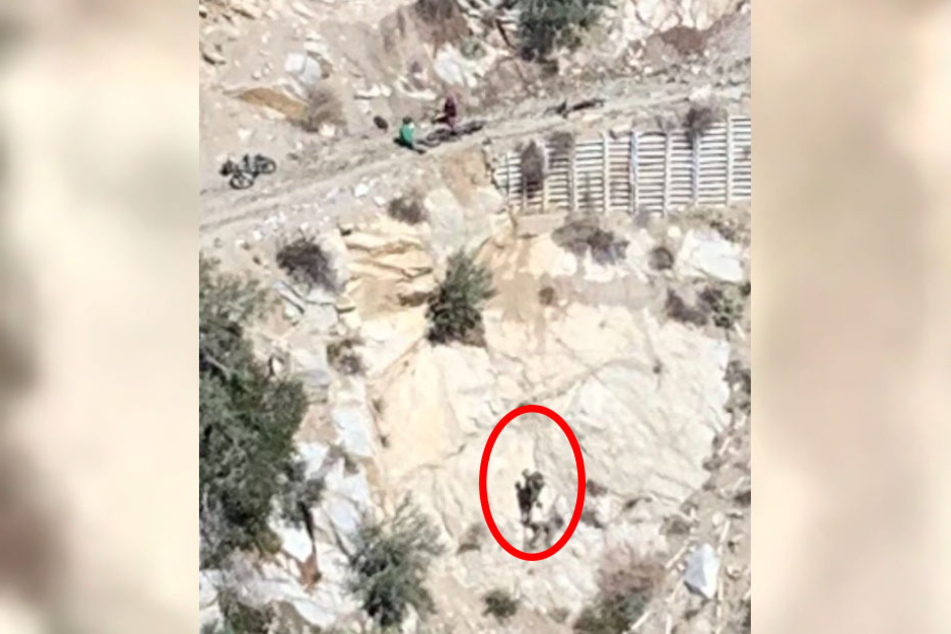 Mountain biker hangs on for dear life before being dramatically rescued