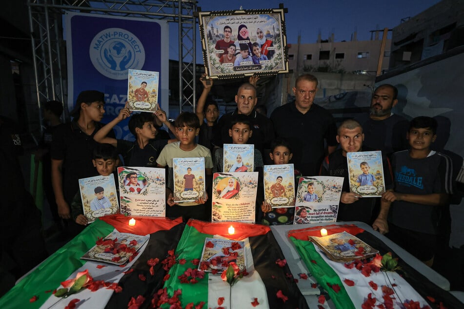 Palestinian mourners gather during a mass funeral procession in the al-Daraj neighborhood of Gaza City on October 17, 2026, following the recovery of the remains of nearly 85 bodies from beneath the rubble of buildings destroyed by Israeli strikes.