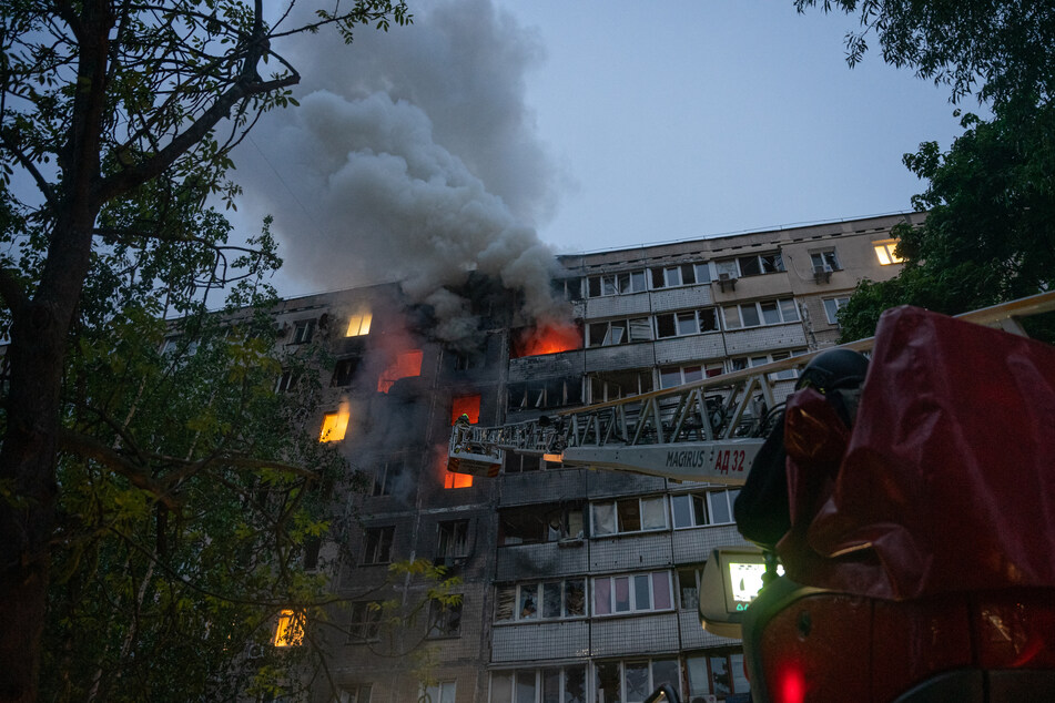 This handout photograph taken and released by the State Emergency Service of Ukraine shows rescuers putting out a fire in a residential building following a Russian drone attack, in Kyiv, on Wednesday, amid the Russian invasion of Ukraine.