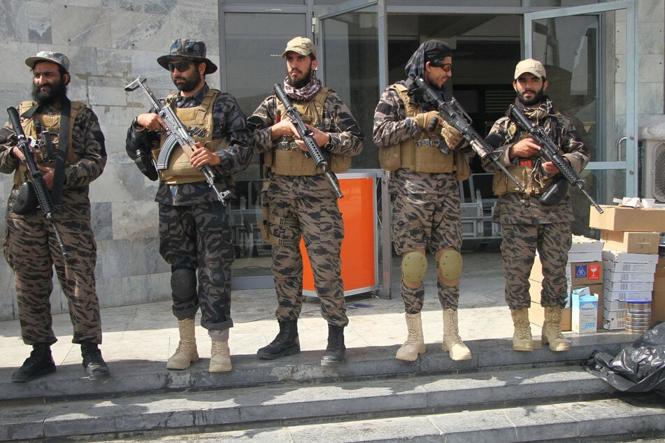 Taliban members lined Kabul airport after Monday's announcement that the withdrawal of US troops from Afghanistan has been completed.