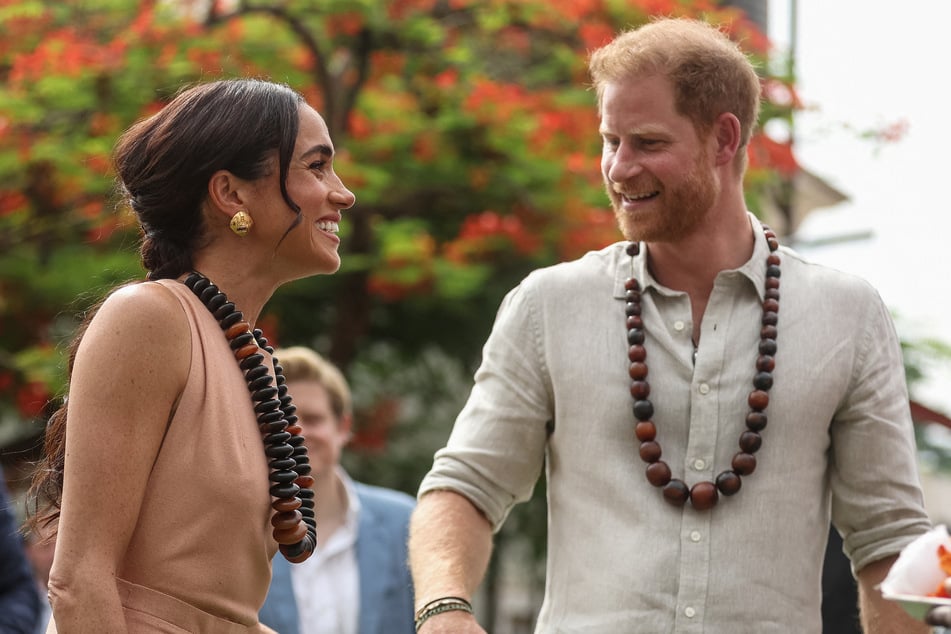 Prince Harry (r.) and Meghan Markle reportedly scored free flights from a man who is wanted in the US for alleged money laundering and million-dollar fraud.