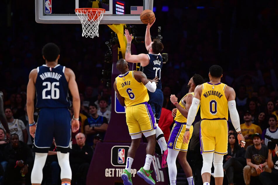Dallas Mavericks guard Luka Doncic moves to the basket against Los Angeles Lakers forward LeBron James during overtime at Crypto.com Arena.