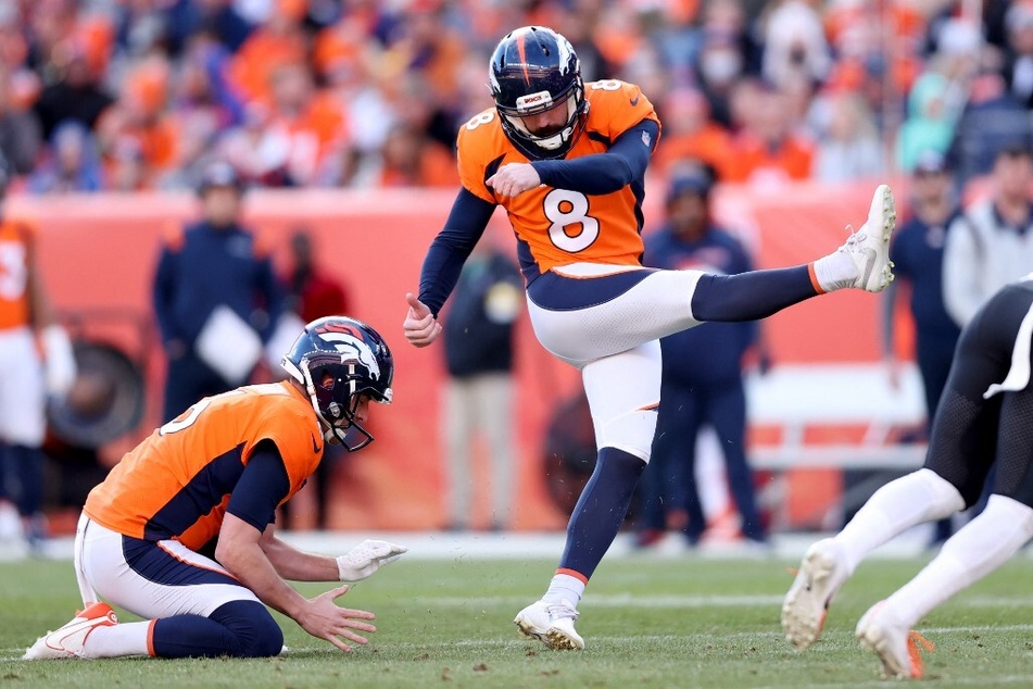Sam Martin holds while Brandon McManus of the Denver Broncos kicks a field goal against the Cincinnati Bengals.