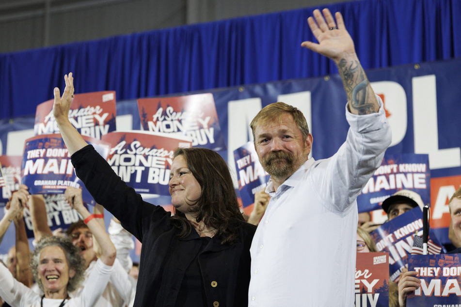 Graham Platner and his wife, Amy Gertner, wave to supporters as they arrive at his primary election event in Blue Hill, Maine, on June 9, 2026.