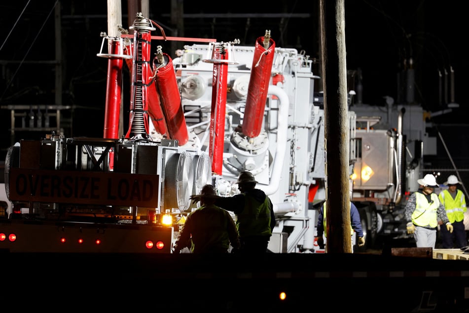 Duke Energy personnel work to restore power at a crippled electrical substation after the Moore County sheriff said vandalism had caused a mass power outage, in Carthage, North Carolina.