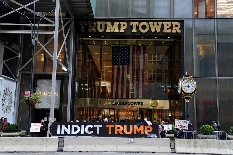 Protesters hold up signs outside Trump Tower in New York City calling for the indictment of Donald Trump.