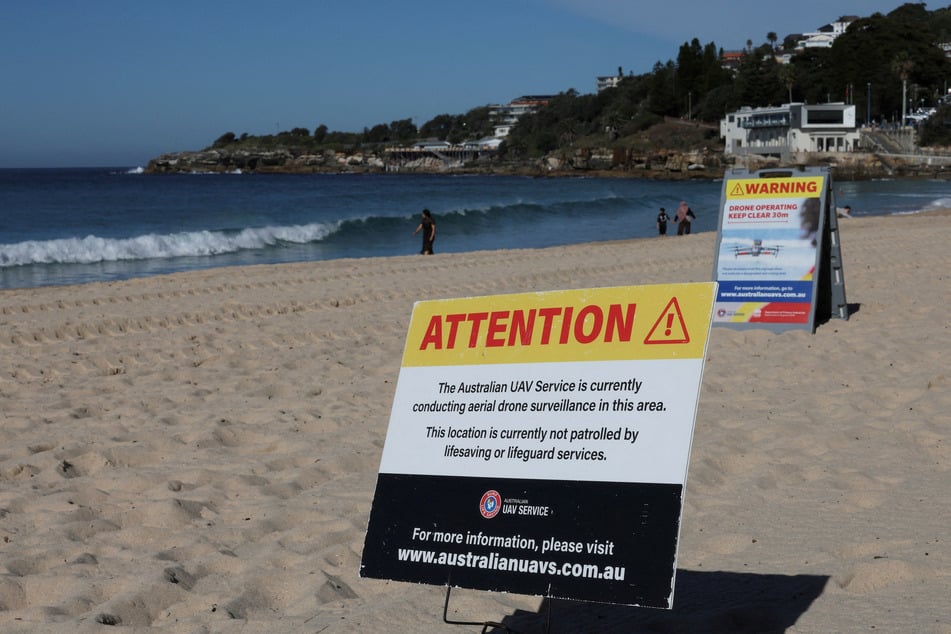 A sign notifying the public that shark-drone surveillance is operating in the area is displayed at Coogee Beach in Sydney, Australia, on June 16, 2026.