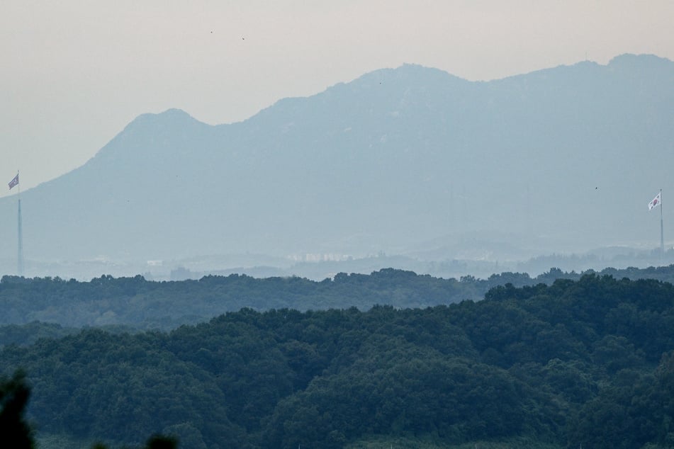 National flags of South Korea and North Korea (l.) are seen within the Demilitarized Zone dividing the two Koreas on September 12. Seoul has now blamed North Korean landmines for a blast in the DMZ that wounded three South Korean military officers.